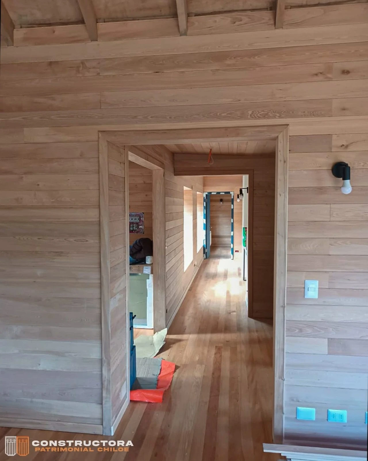 Interior de Casa Los Capurro con cielo de madera a la vista y pasillo iluminado por luz natural